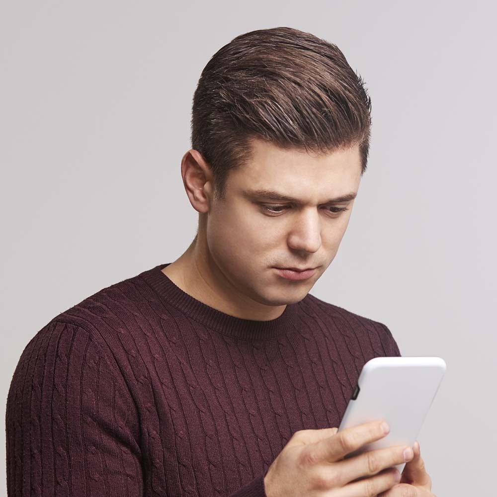 portrait-of-a-young-white-man-using-a-smartphone-PBFJNAY.jpeg